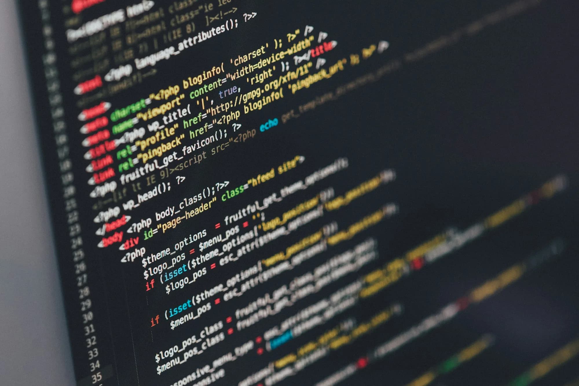 Developer writing code on multiple monitors